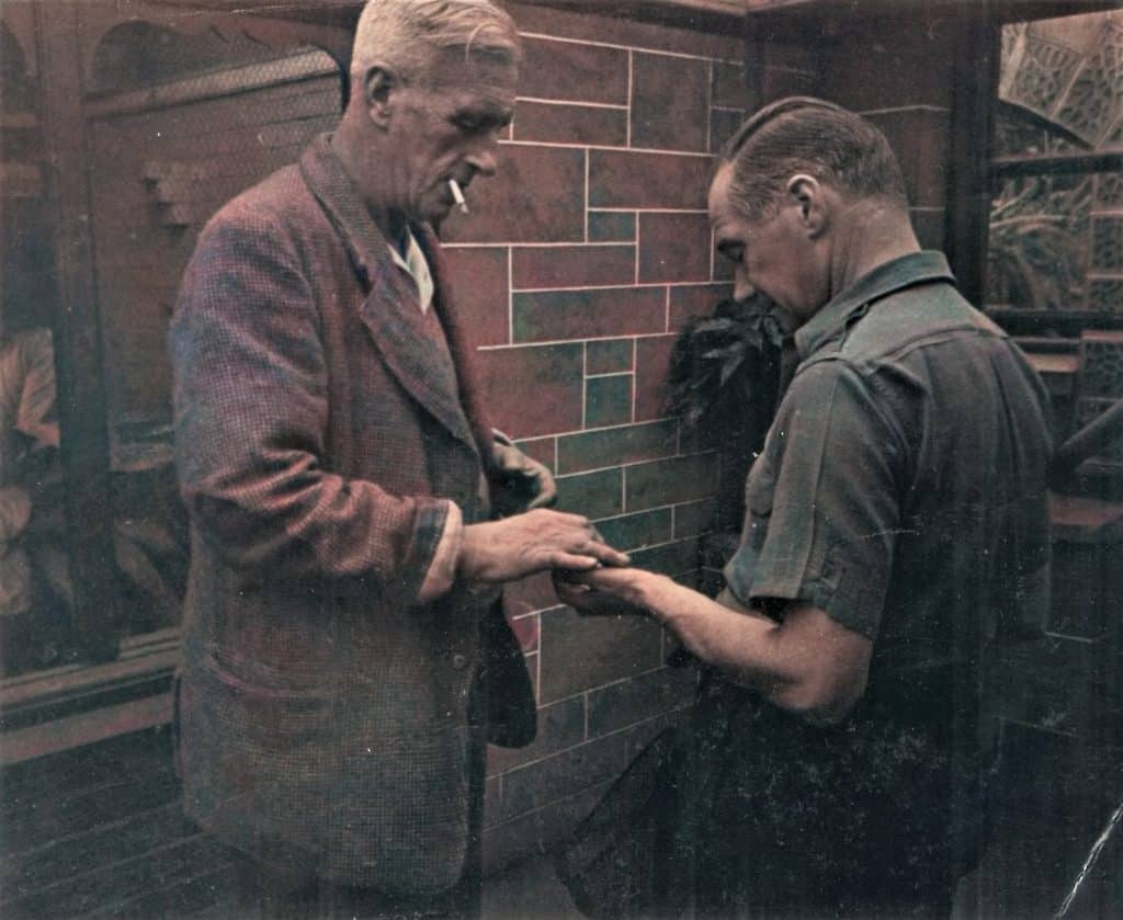 Colorised photo of Paignton Zoo founder Herbert Whitley meeting aquarium curator Harry Sinclair in the subtropical house